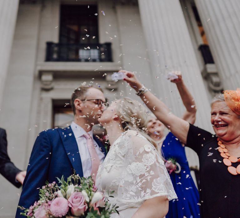 Confetti moment for bride and groom before they step onto London wedding bus