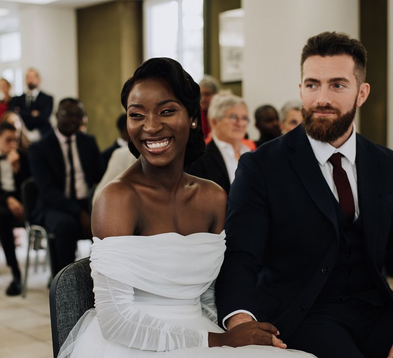 Stylish bride and groom smiling during the civil ceremony 