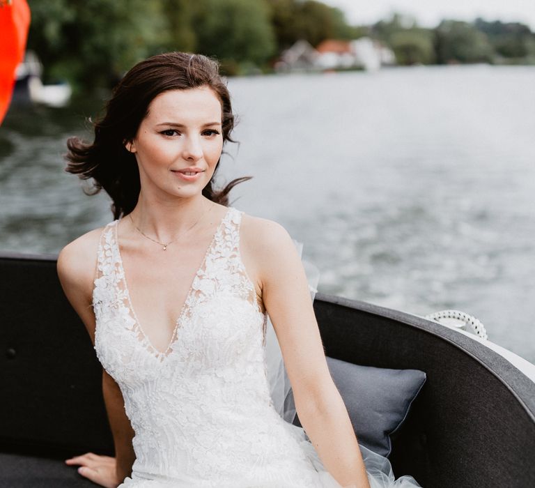 Bride poses on boat during her wedding reception 