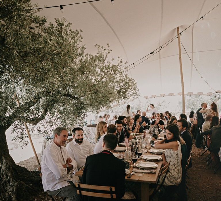 Guests at narrow tables for buffet wedding food