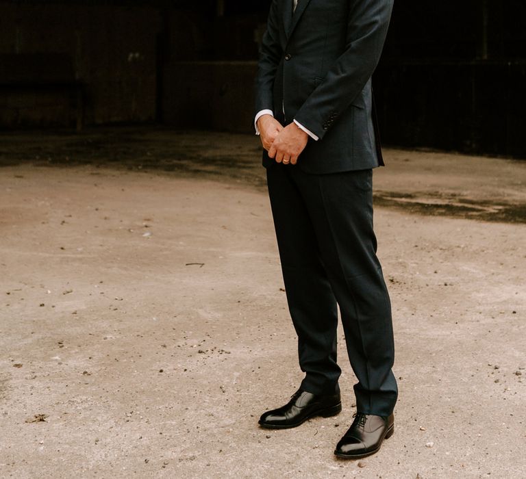 Groom in navy lounge suit at Clock Barn wedding