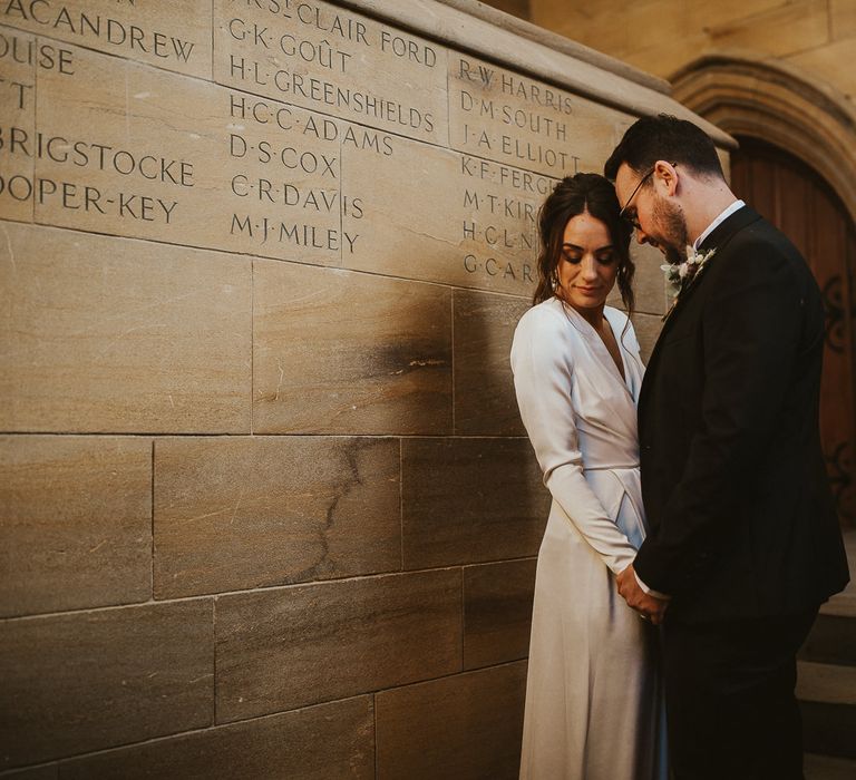 Bride & groom pose together in stairwell after wedding ceremony