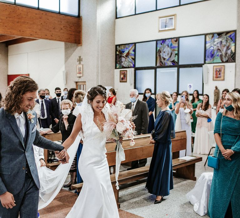 Bride and groom walking down the aisle together at their Italian destination wedding 