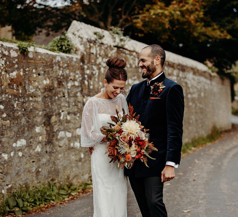 Bride & groom stand together outdoors after wedding ceremony