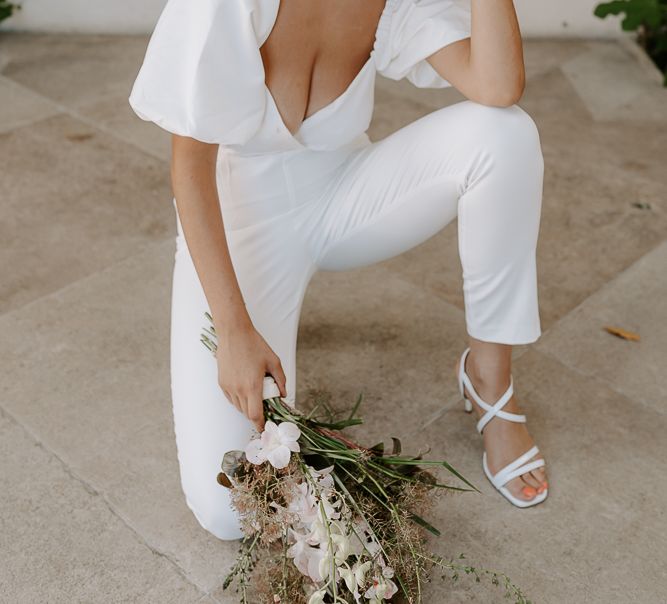 Bridesmaid with brown hair wearing a fitted jumpsuit with taper legs and puff sleeves 