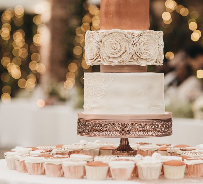 White and blush wedding cake with Lace detail, ruffle design and flower cake topper 