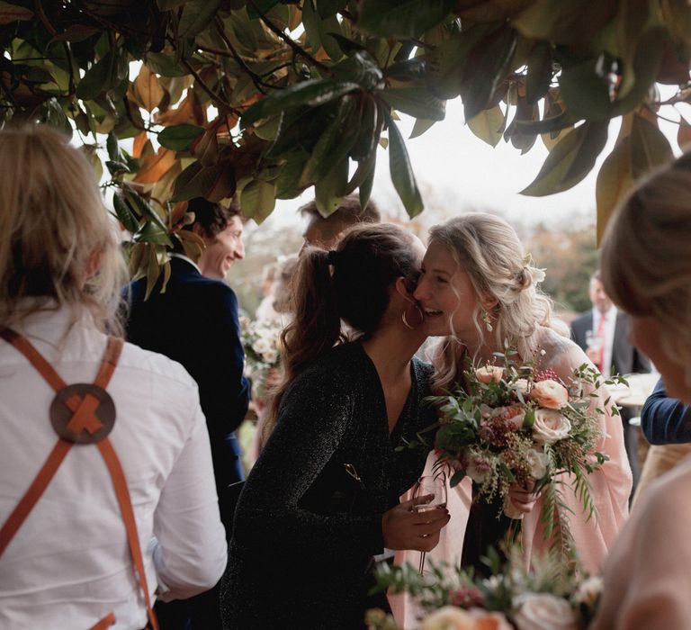 Wedding guests hugging at garden wedding