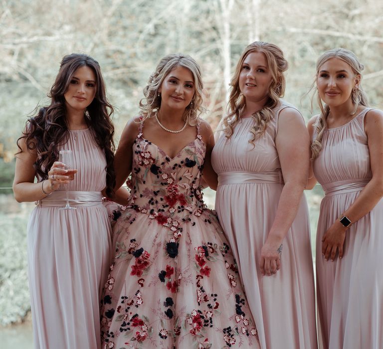 Bride stands with bridesmaids on her wedding day 