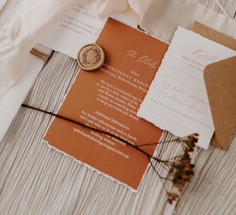 Beautiful burnt orange wedding stationery tied with cream silk ribbon