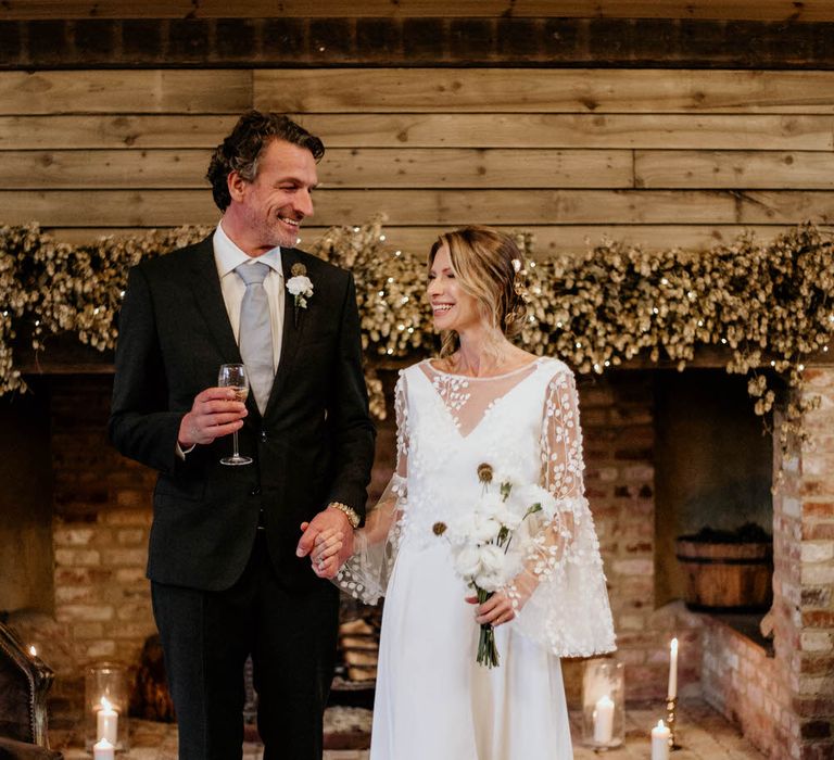 Bride and groom holding hands at the altar and drinking wine from High Clandon