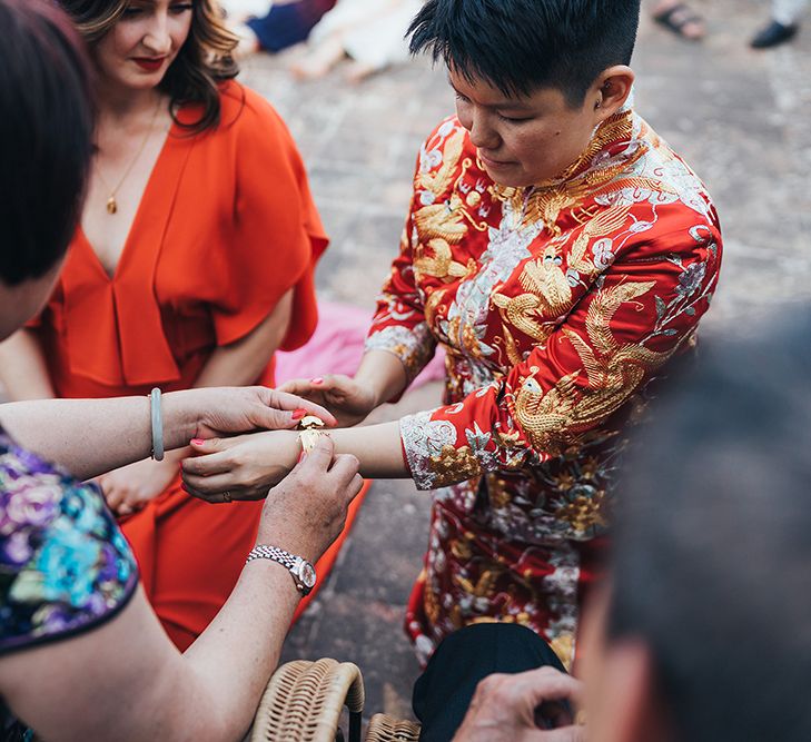 Bride has bracelet given to her by wedding guest