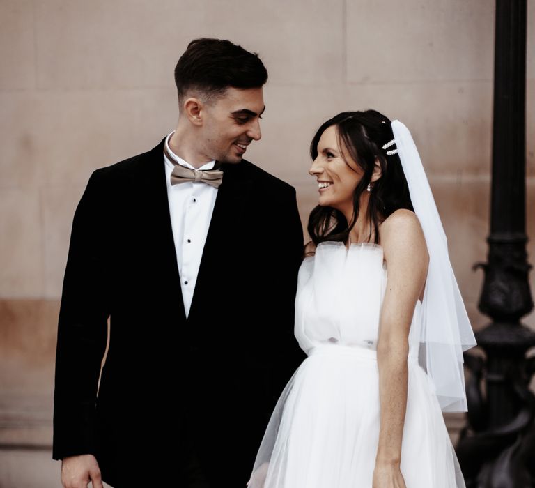 Bride & groom look lovingly at one another outdoors on the morning of their wedding day