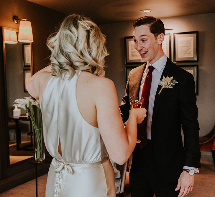 Bride and groom first look with bride in a satin halter neck wedding dress 