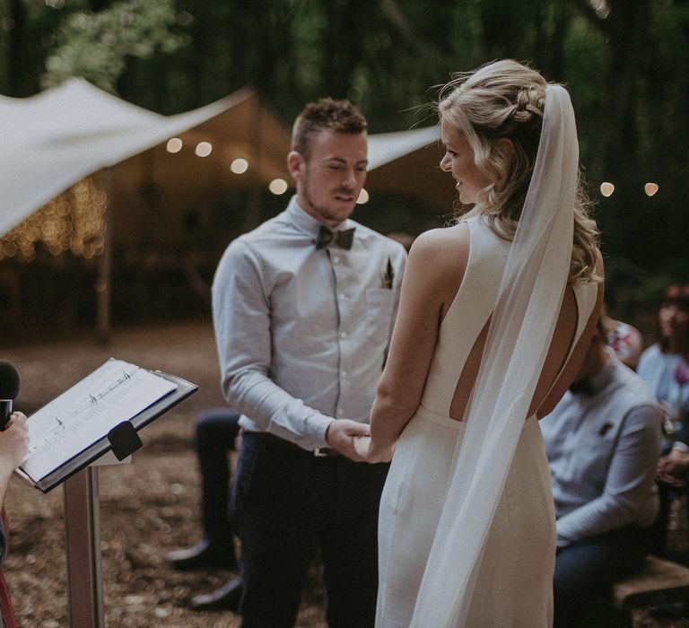 Bride & groom listen as little girl gives reading on their wedding day at the front of the aisle