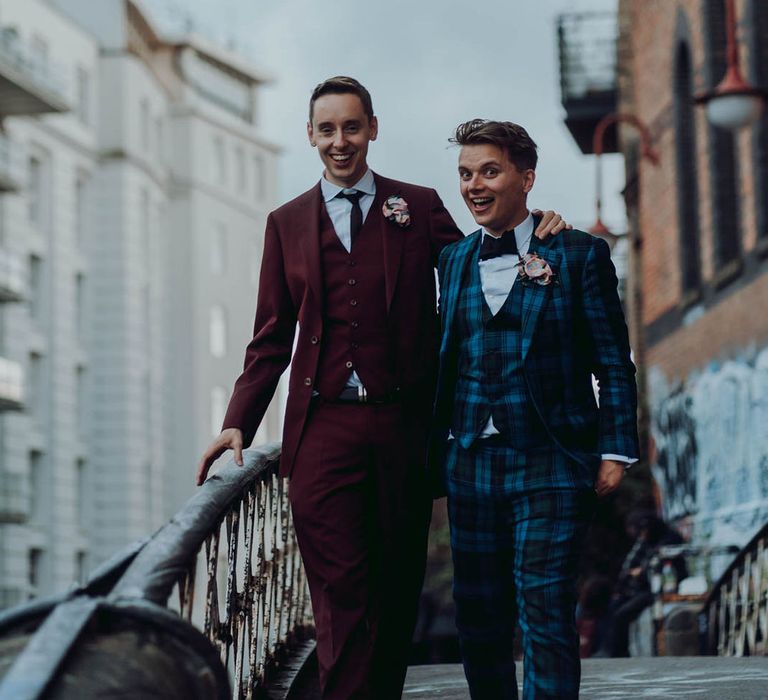 Grooms stand on balcony outdoors whilst wearing suits  | Kim Williams Weddings