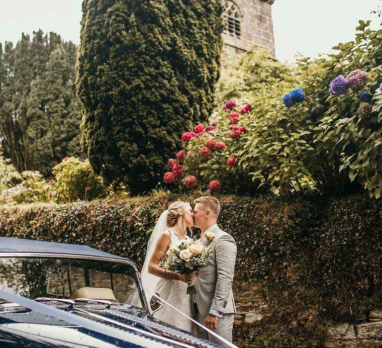 Bride and groom with blue vintage wedding car