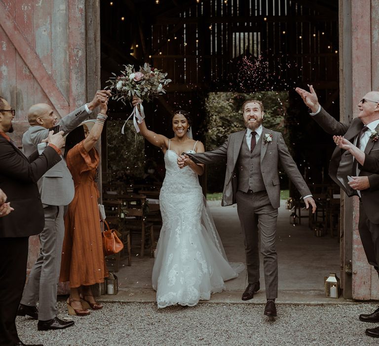 Bride & groom celebrate as they leave wedding ceremony