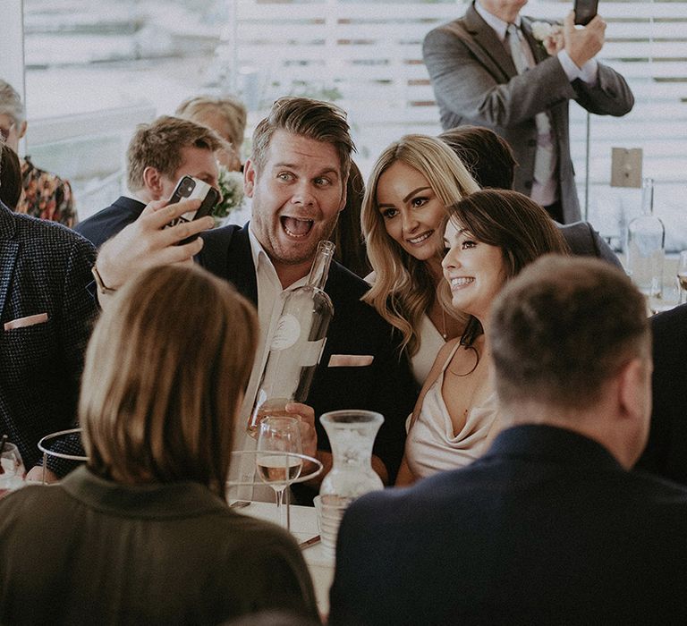 Wedding guests take selfies with bride