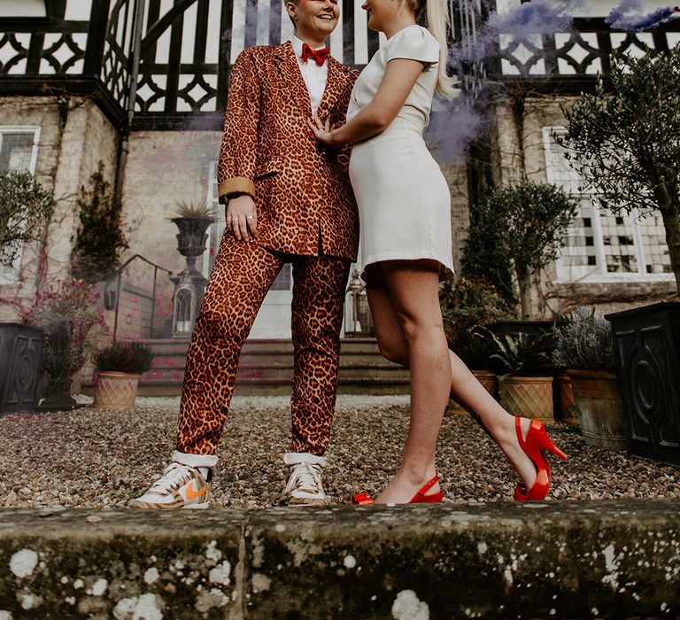 Two brides at retro wedding at The high field House with leopard print suit, short wedding dress and bow accessories 