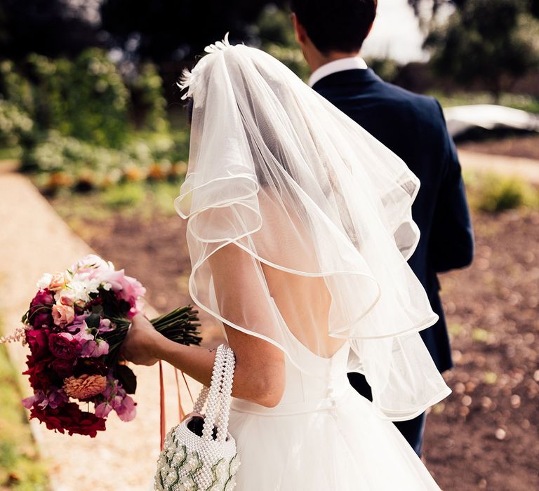 Bride carries pearl bag on her wedding day 