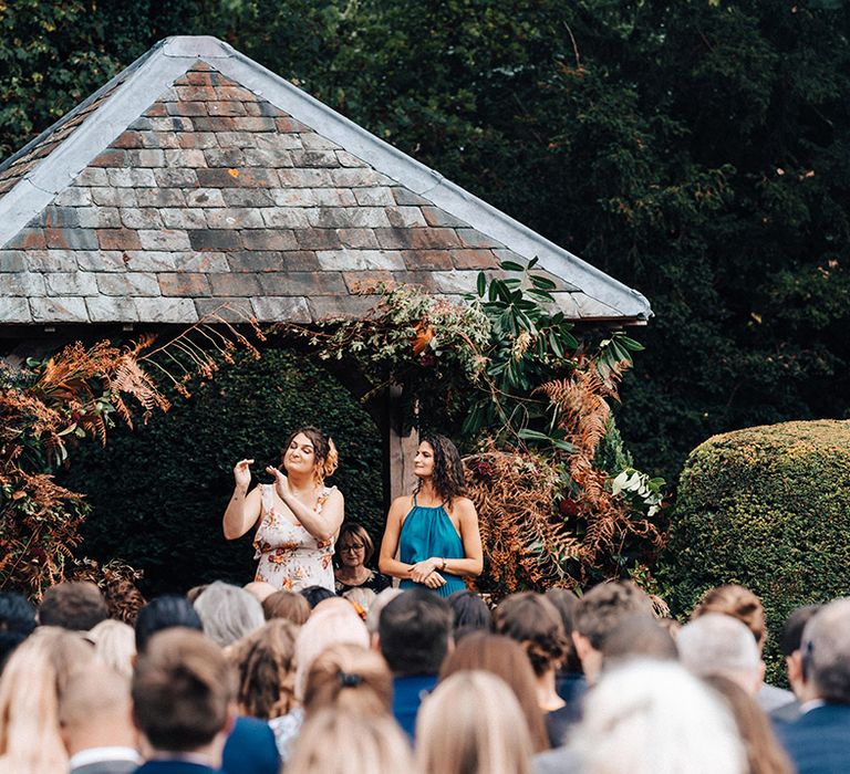 Guests give their wedding speeches in sign language for the deaf wedding guests and couple