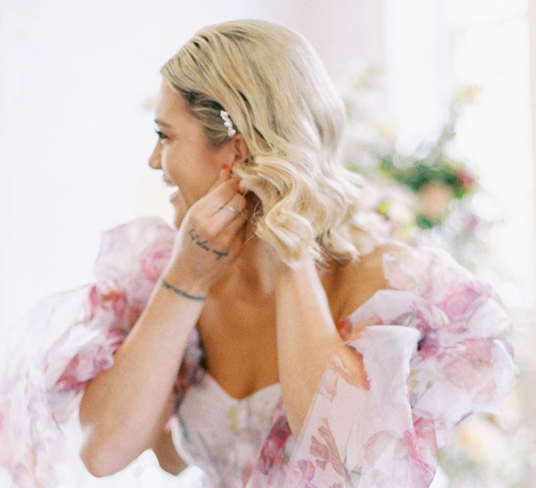 Bride in a pink floral patterned princess wedding dress with bows on the sleeve