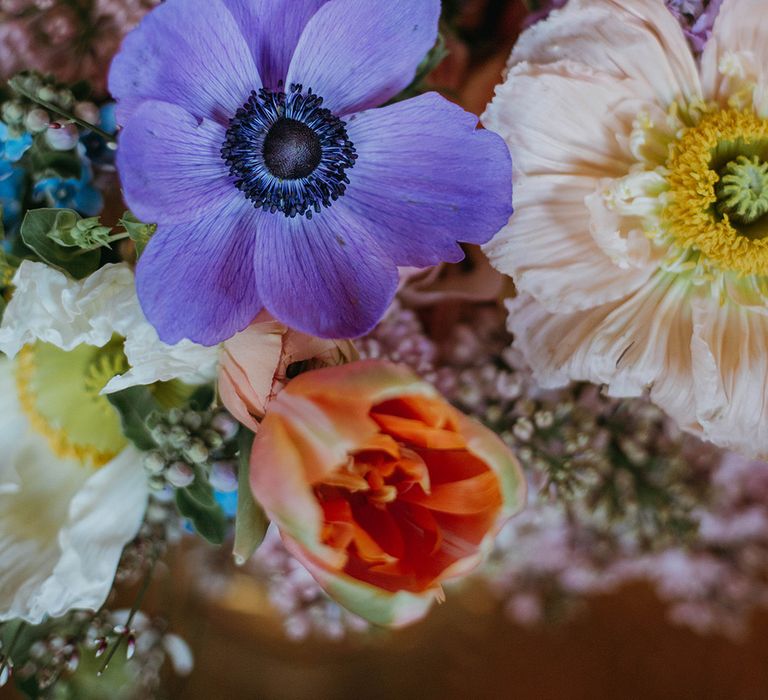 Spring wedding bouquet with purple, yellow, orange, pink and blue for fun festival theme wedding at Loft Studios