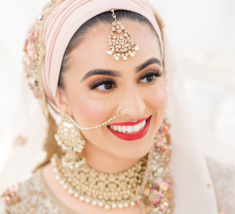 Bride wears red lipstick and traditional gold jewellery for Walima at the Isla Gladstone Conservatory