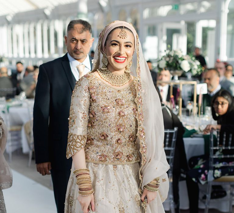 Bride smiles brightly on her wedding day wearing traditional saree and red lipstick 