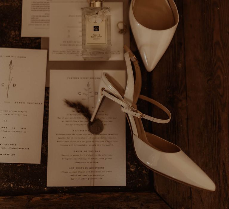 White patent slingback wedding shoes with wedding stationery and Jo Malone perfume 