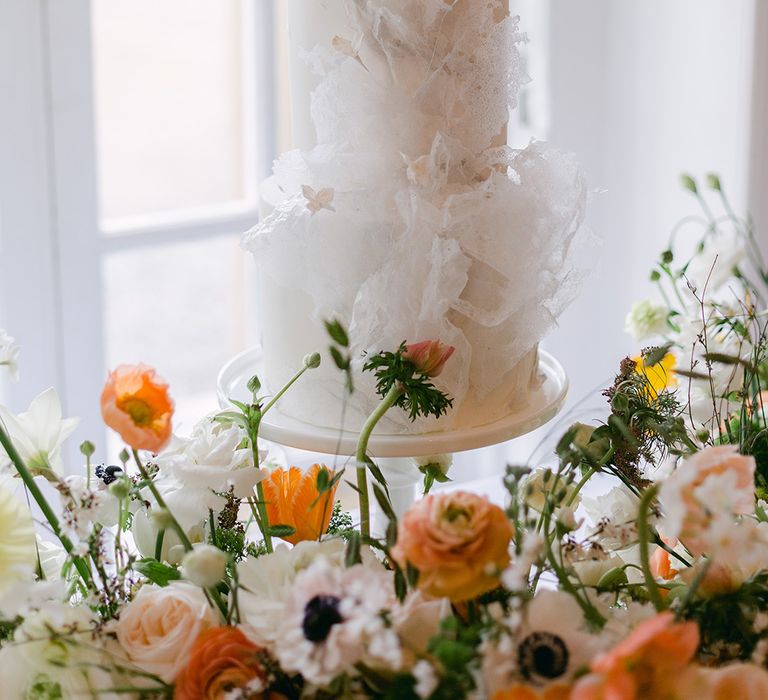 Three tier traditional and simple white wedding cake with textured detail design 