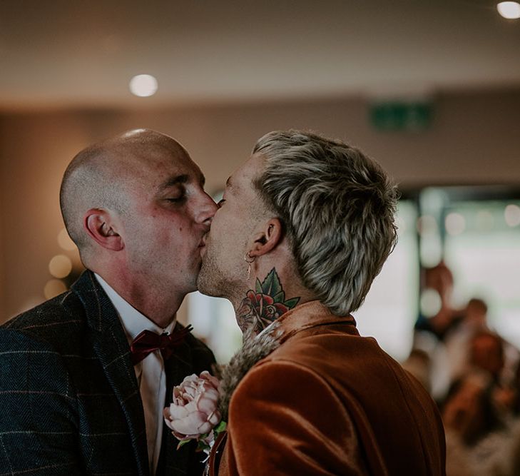 Grooms kiss on their wedding day during boho chic ceremony 