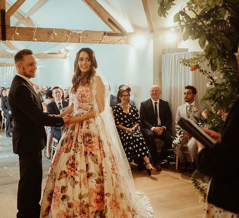 Bride and groom stand at the altar holding hands 