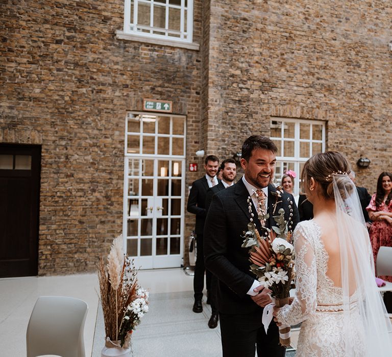 Bride wears cathedral veil in her low bun 