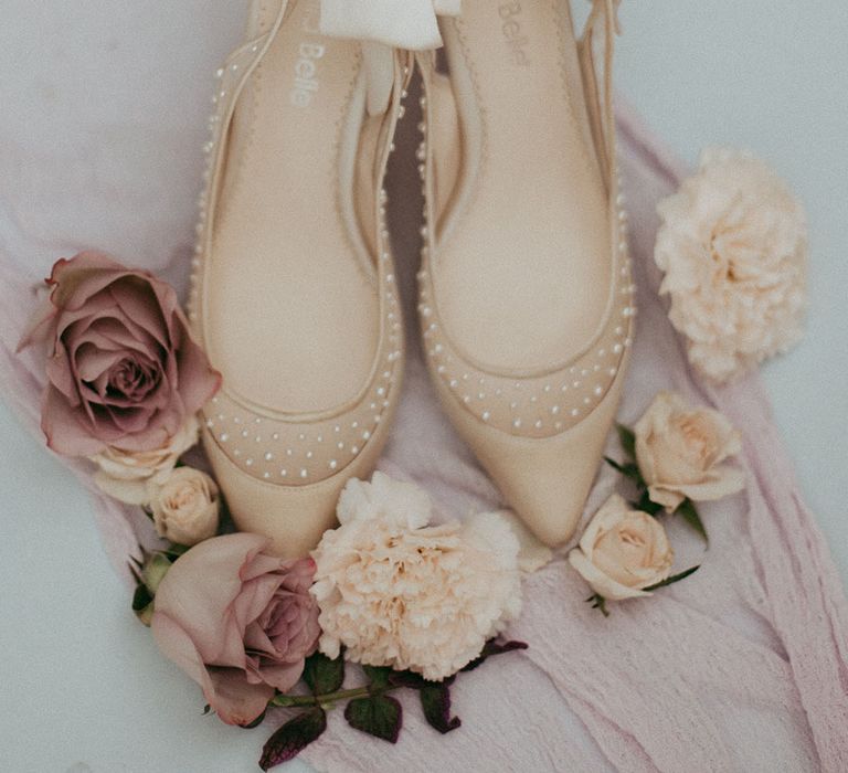 Cream Bella Belle high heels with pearls, surrounded by neutral, pink and white roses