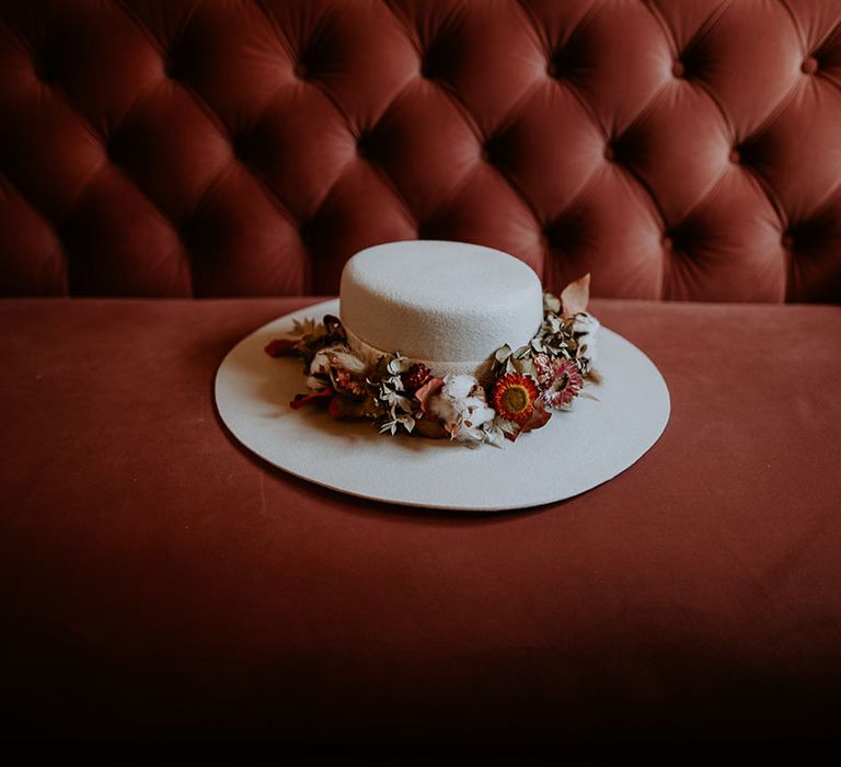 White wedding hat with colourful wedding flowers decorating the hat 