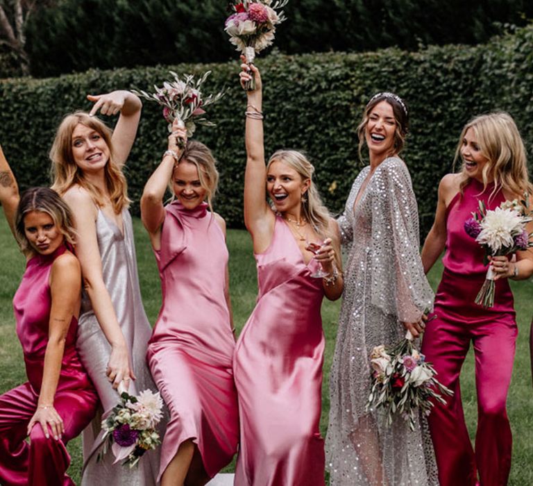 Bridesmaids in light pink and dark pink dresses and jumpsuits for a fun alternative wedding with the bride in a sequin wedding dress 