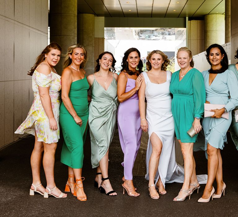 Bride stands with her bridesmaids in mismatched bridesmaid dresses 