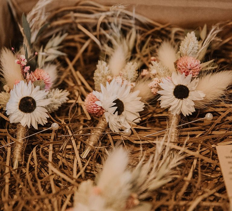 Preserved flower pink and white wedding buttonholes with boho dried grass 