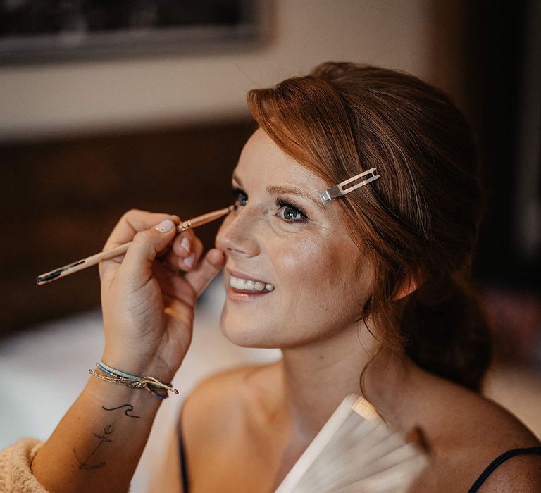 Bride has her makeup done on the morning of her wedding day