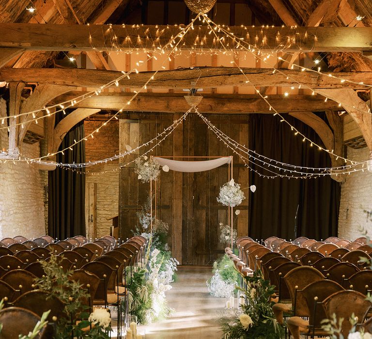 The Tythe Barn Launton barn wedding venue decorated with white wedding flowers with wedding fairy lights 