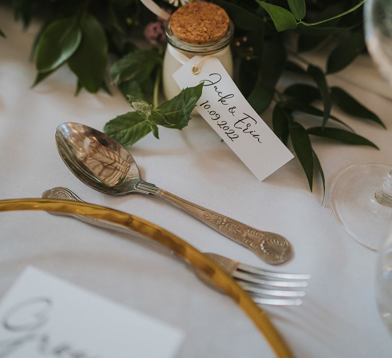 Pink, purple, and white wedding flowers decorating the table with mini wedding favours with personalised label 