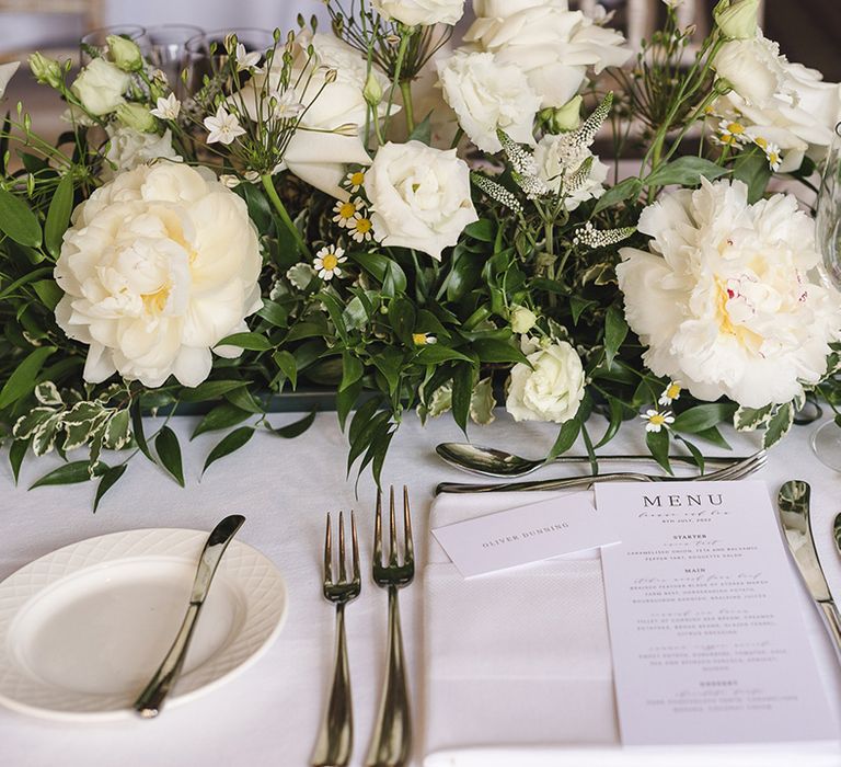 Classic and traditional black and white wedding menu and place setting with white flower arrangement decoration 