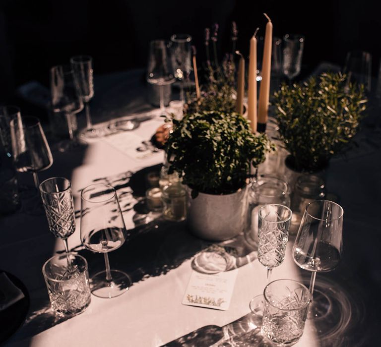 Wedding table setting with black plates, white napkins, crystal slice place names, and thank you charity donation wedding favours 