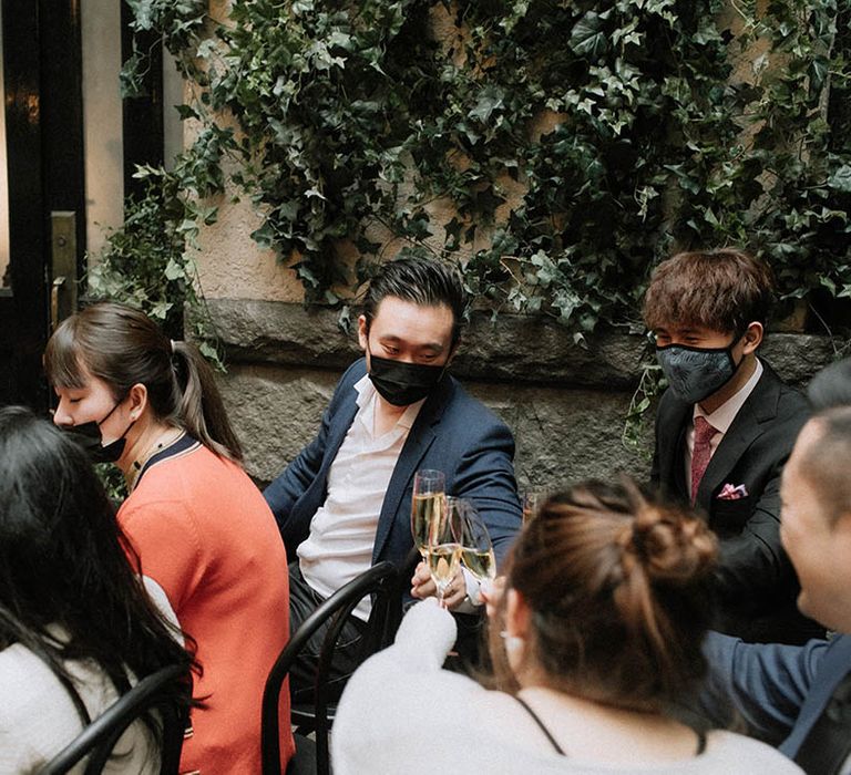 The wedding guests seated at the ceremony drink champagne together to celebrate the union 