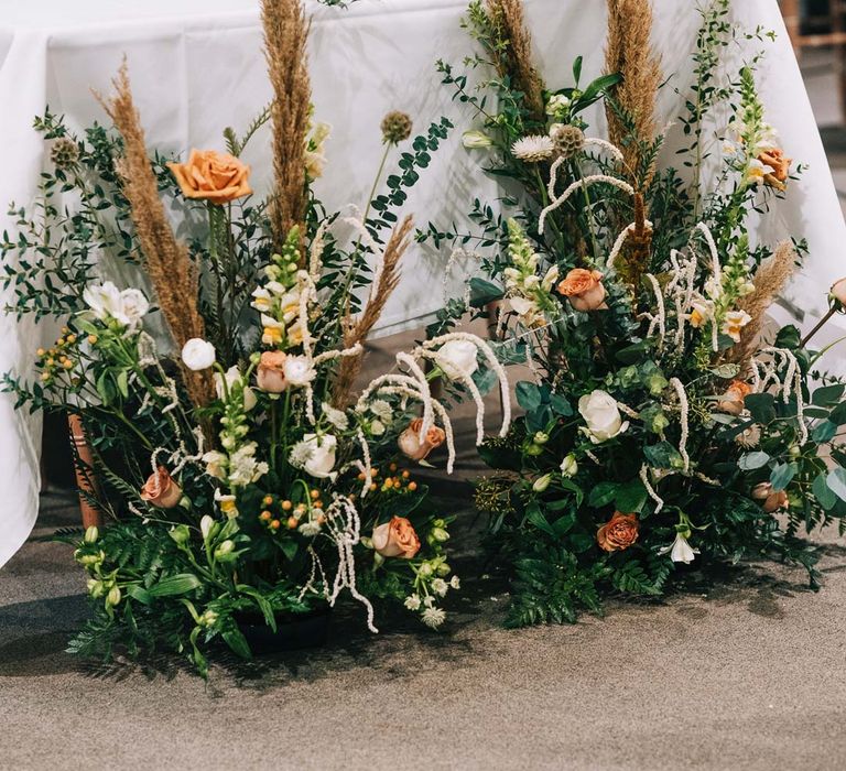 Pampas grass, eucalyptus, blush garden roses, dried flowers and foliage wedding flower arrangements at rustic wedding tablescape at South Farm wedding