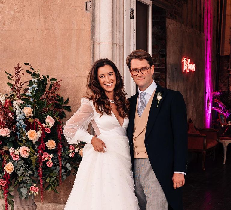 Bride in pearl wedding gown with pink Louboutin bridal shoes with the groom in a morning suit for the traditional wedding 