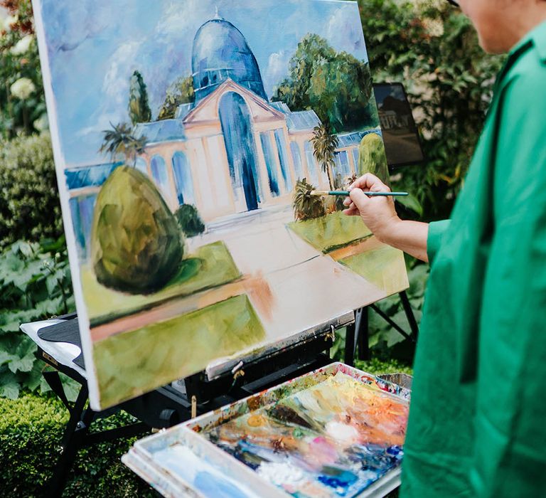 A live wedding painter at a stunning real wedding painting the wedding venue 