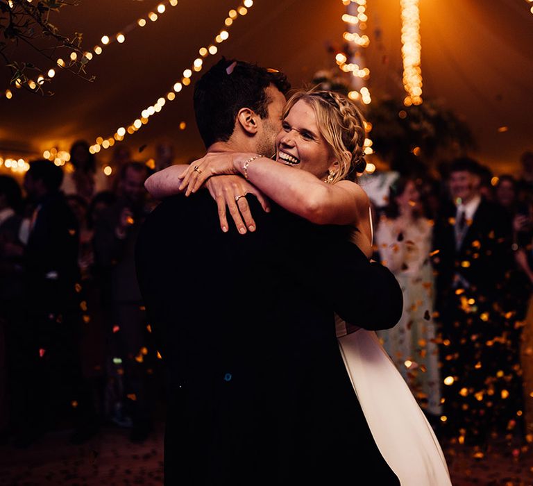 Gold shiny wedding confetti falling around bride and groom having their first dance 