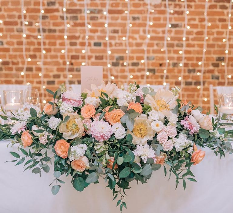 Seasonal wedding flower arrangement with roses and dahlias on the top table